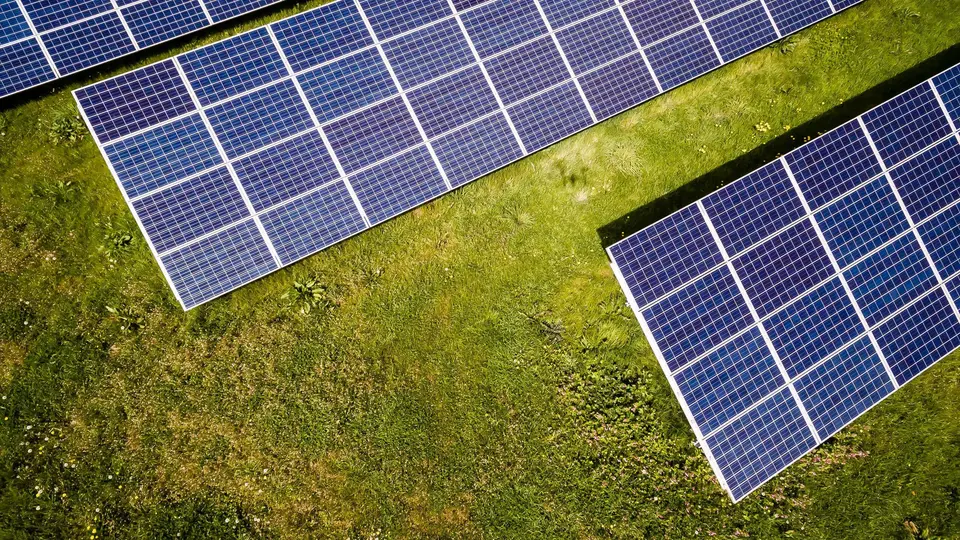 Aerial view of photovoltaic module rows on grassland